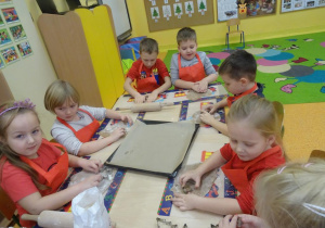 Dzieci wycinają pierniczki foremkami.